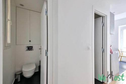 La salle de bains est pourvue de toilettes et d'une armoire blanche. dans l'établissement Charming Studio -2 persons - Paris 10, à Paris