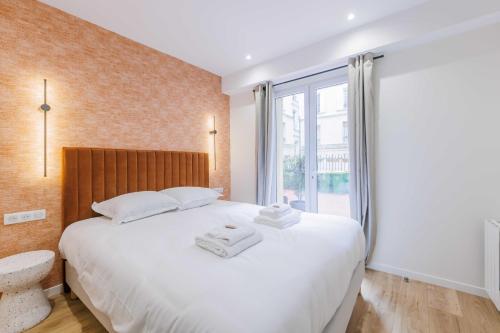 une chambre avec un grand lit blanc et une fenêtre dans l'établissement Cozy Apartment 2BR-6P - Sacré-Coeur - Montmartre, à Paris