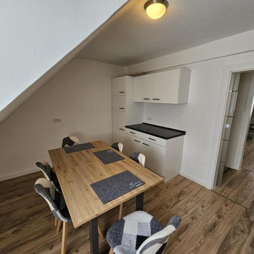 a small kitchen with a wooden table and chairs at Beautiful Apartments in Hanau in Hanau am Main
