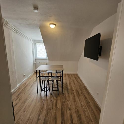 a dining room with a table and two stools at Beautiful Apartments in Hanau in Hanau am Main