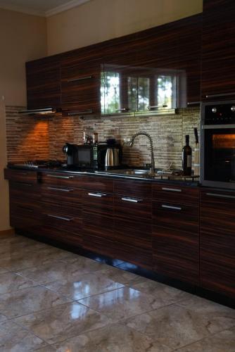 a kitchen with wooden cabinets and a sink and a microwave at Villa Aragvi in Mtskheta