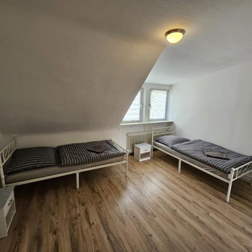 two beds in a room with wooden floors at Beautiful Apartments in Hanau in Hanau am Main