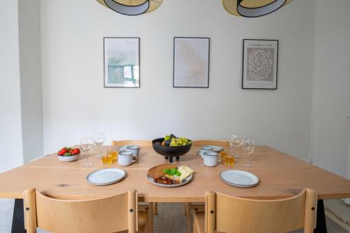 a wooden table with a bowl of fruit and wine glasses at Super Central 2BR Apartment in Old Town Copenhagen in Copenhagen