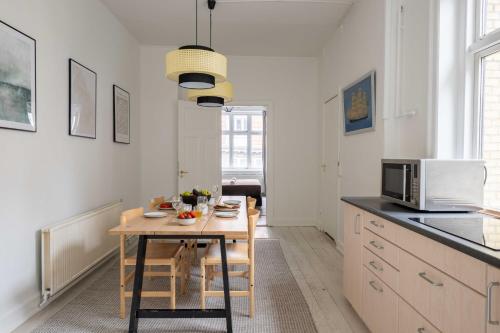 a kitchen with a table with chairs and a microwave at Super Central 2BR Apartment in Old Town Copenhagen in Copenhagen