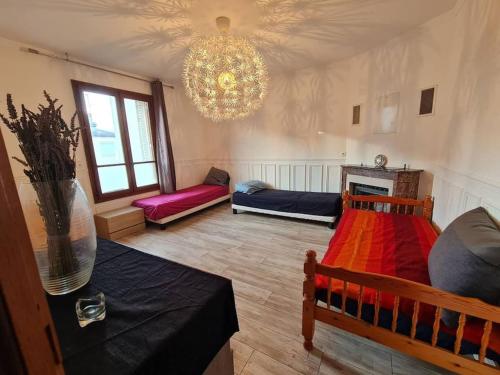 - un salon avec deux lits et un lustre dans l'établissement Grand Appart - avec terrasse, à Reims