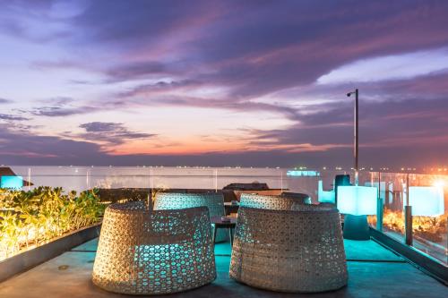 a balcony with chairs and a view of the ocean at Seaphere Pattaya Hotel by Elite Suites in Na Jomtien