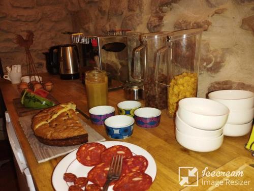 una mesa cubierta con un plato de comida y pan en Logis Hotel Restaurant L'Esquielle, en Saint-Géniès-de-Malgoirès