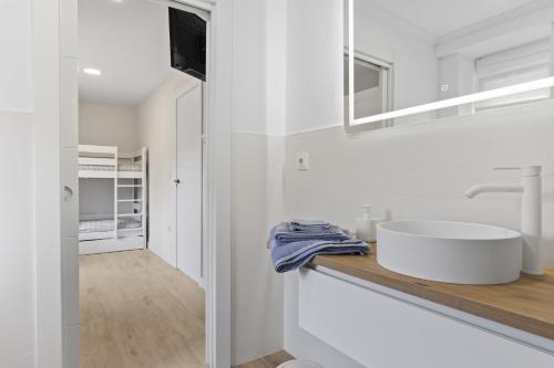 a white bathroom with a sink and a mirror at La Casuca del Músico in Novales