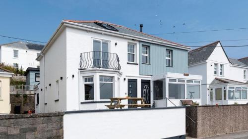 a white house with a fence in front of it at HipNautic, Mevagissey, Sleeps 6 in Mevagissey