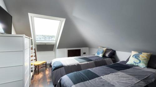 a bedroom with two beds and a window at HipNautic, Mevagissey, Sleeps 6 in Mevagissey