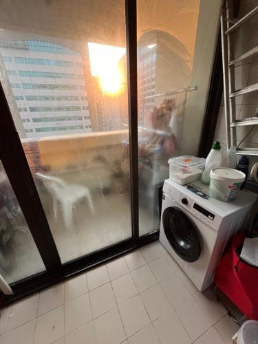a washing machine in a kitchen with a window at Managa-naga Room1204 near abu dhabi mall in Abu Dhabi