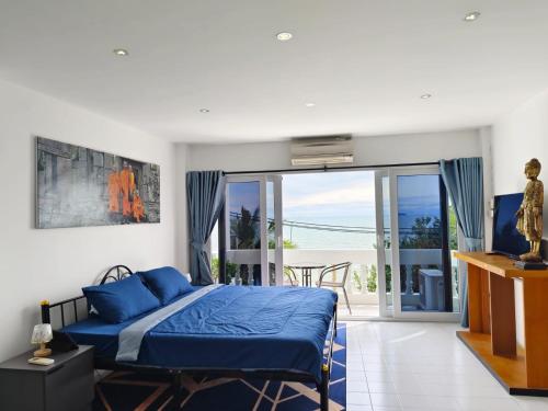 a bedroom with a blue bed and a balcony at Beach Villa NA JOMBTIEN ROOF TOP in Na Jomtien