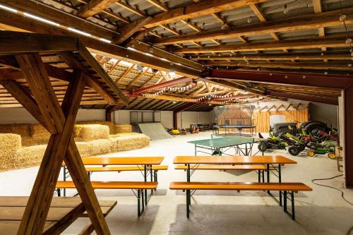 a large room with tables and ping pong tables at Heide Ferien - Hof Bockelmann in Bispingen