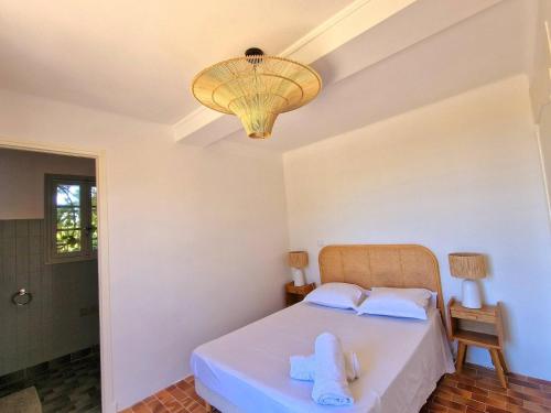 une chambre avec un lit et un lustre dans l'établissement Villa Marguerite T3 vue mer, à Bandol