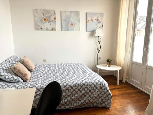 une chambre avec un lit et une table avec une lampe dans l'établissement Charmant appartement - Gare SNCF-RER et sites JO 2024, à Saint-Cyr-lʼÉcole
