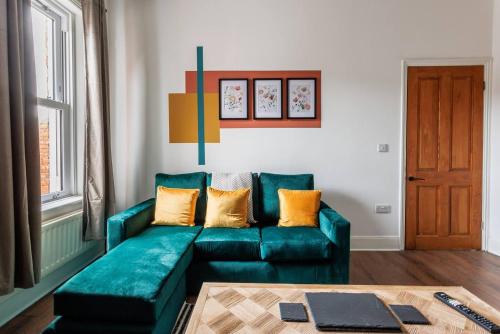 a living room with a green couch and a table at 3br Homely House For Family, Friends And Workers in Gateshead