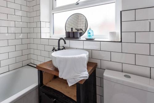 a bathroom with a sink and a mirror and a tub at 3br Homely House For Family, Friends And Workers in Gateshead