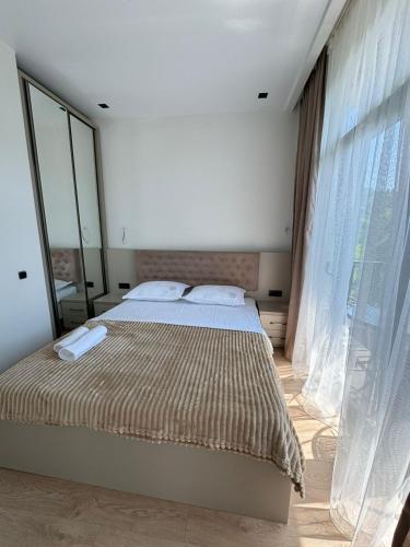 a bedroom with a bed and a large window at Veranda White House in Batumi