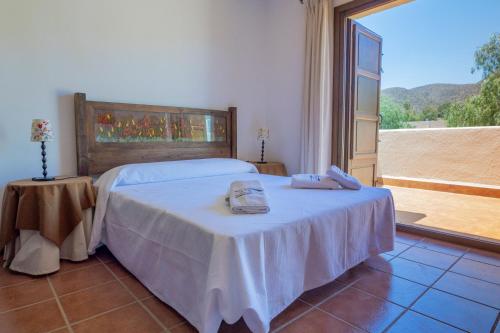 Un dormitorio con una cama con dos toallas encima. en El Olivo, en San José