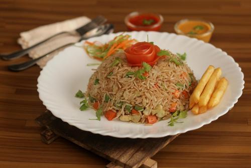 a plate of food with rice and carrots and french fries at Rinte Green Village & Bukit Lawang Jungle Trekking in Bukit Lawang