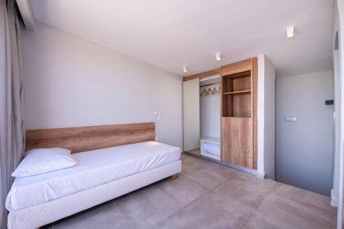 a small bedroom with a bed and a closet at Kiani Beach Resort Family All Inclusive in Kalyves