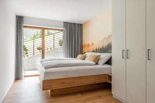 a bedroom with a bed and a window at Apparthotel Sonnwies in Selva dei Molini