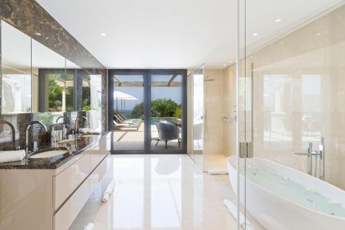 une salle de bain avec une baignoire, une douche et un lavabo dans l'établissement Les Dauphins, à Saint-Jean-Cap-Ferrat