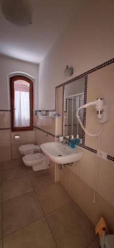 a bathroom with a sink and a toilet and a mirror at Nurache in Orosei