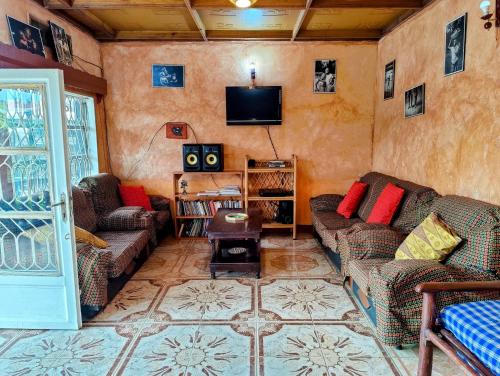 un soggiorno con divani e TV a schermo piatto di Amahoro Guest House a Ruhengeri