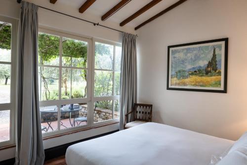 a bedroom with a bed and a large window at Tenuta Torre Rossa Farm & Apartments in Impruneta