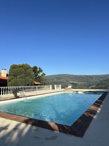 a swimming pool with blue water in the middle at Quinta da Touça in Baião
