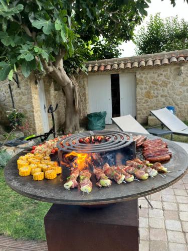 a grill with meat and other food on it at Chambres d'hôtes la Soulenque Luxury B & B in Capestang