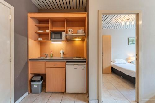 a small kitchen with a sink and a microwave at Condo Gardens Brussels in Brussels