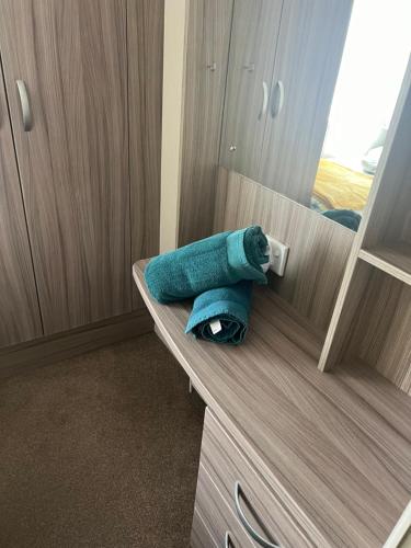 a blue towel sitting on a counter in a bathroom at Marigold lodge 8 at Oakdene Forest Park in Saint Leonards