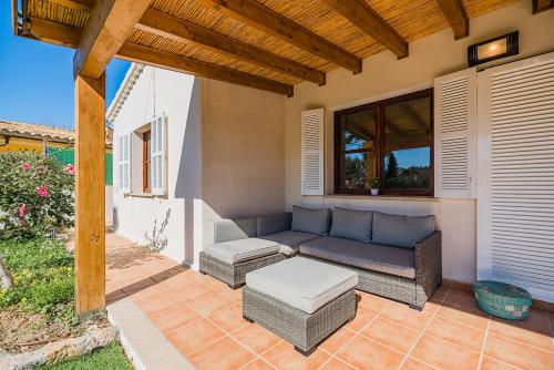 a patio with a blue couch and ottoman at Can Singala 46 in Port de Pollensa