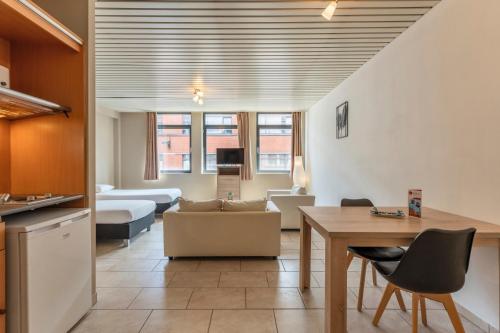 a living room with a couch and a table at Condo Gardens Brussels in Brussels