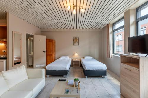 a living room with two beds and a couch at Condo Gardens Brussels in Brussels