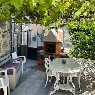 a outdoor patio with a table and a grill at Casa da Alicinha - Férias no Douro in Baião