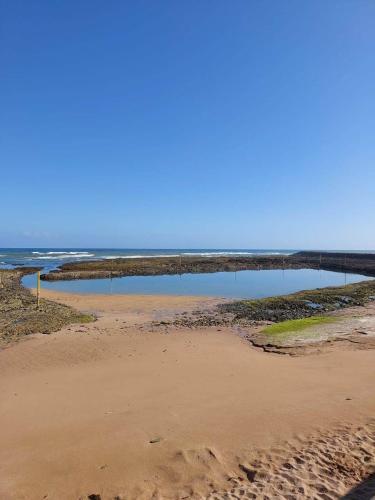 a beach with a pool of water in the ocean at Appartement à Bahia golf Beach Bouznika in Kasba Bou Hamira