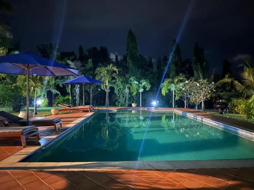 a swimming pool in a resort at night at Jasmin Villa in Mtwapa
