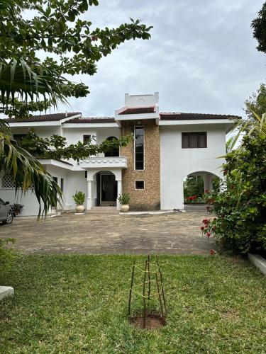 a large white house with a yard at Jasmin Villa in Mtwapa