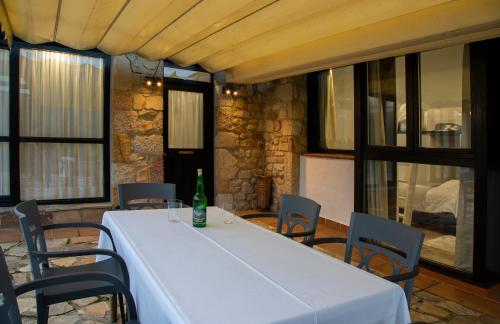 a table with a bottle on it in a room with windows at Hotel Rural Valleoscuru in Tresgrandas