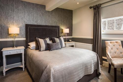 a bedroom with a large bed and a chair at The Lake Isle Restaurant with rooms in Uppingham