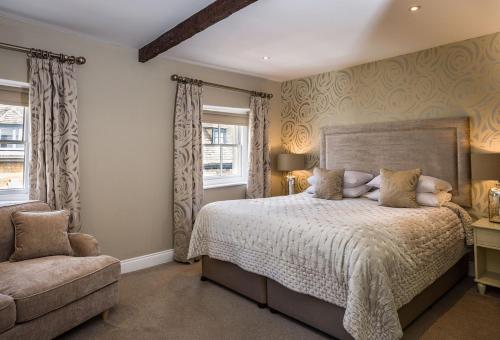 a bedroom with a bed and a chair at The Lake Isle Restaurant with rooms in Uppingham