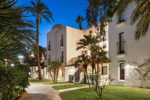 a building with palm trees in front of it at Best Club Vacaciones Pueblo Indalo in Mojácar