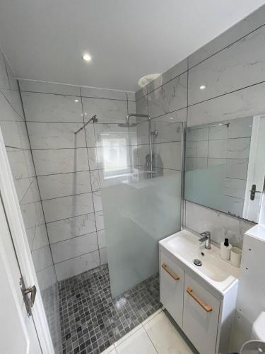 une salle de bain blanche avec une douche et un lavabo dans l'établissement New Garden Unic 6 personnes, à Amiens