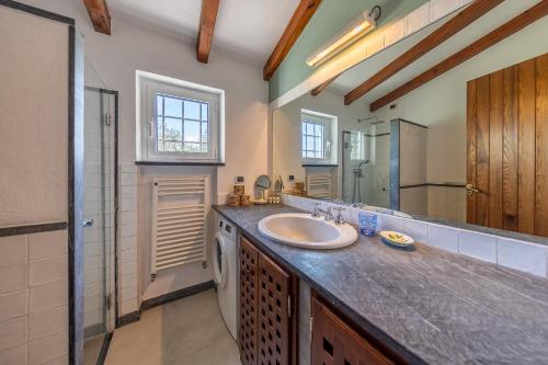 a bathroom with a sink and a mirror at LA CASA DI PIETRA Piscina e Panorama da Sogno in Santa Margherita Ligure
