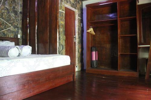 a bedroom with a bed and an open door at Rinte Green Village & Bukit Lawang Jungle Trekking in Bukit Lawang