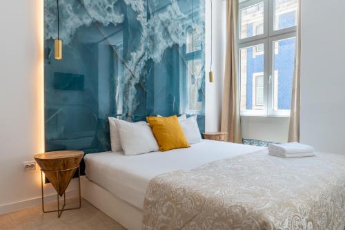 um quarto com uma cama e uma parede azul em Lisbon Studios em Lisboa