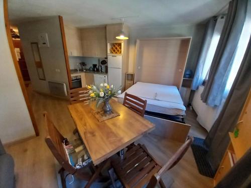 a dining room table with a vase of flowers on it at Altissim Grizzly in Pas de la Casa